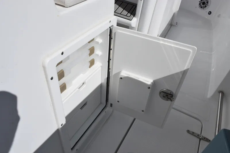 Slide: The Image of 2026 Sea Hunt Gamefish 25 boat storage compartment with open door, showcasing interior design. - 17