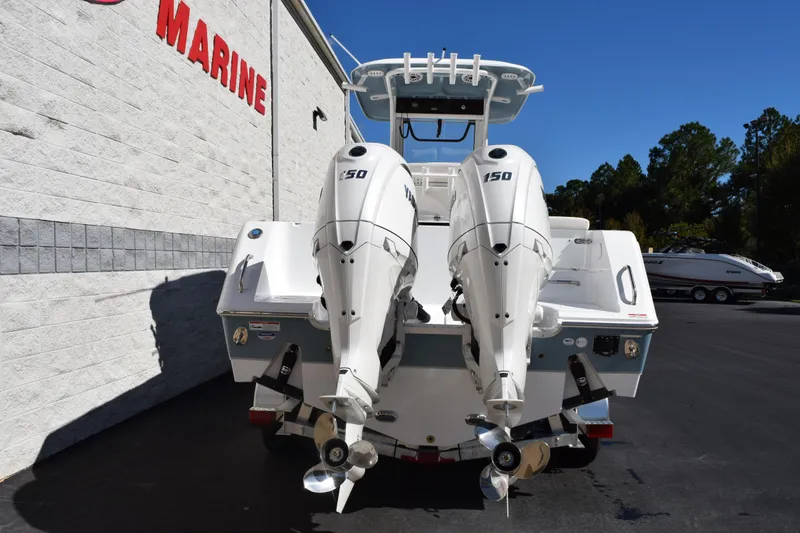 Slide: The Image of 2026 Sea Hunt Gamefish 25 with dual 150 horsepower engines, parked at a marine dealership. - 5