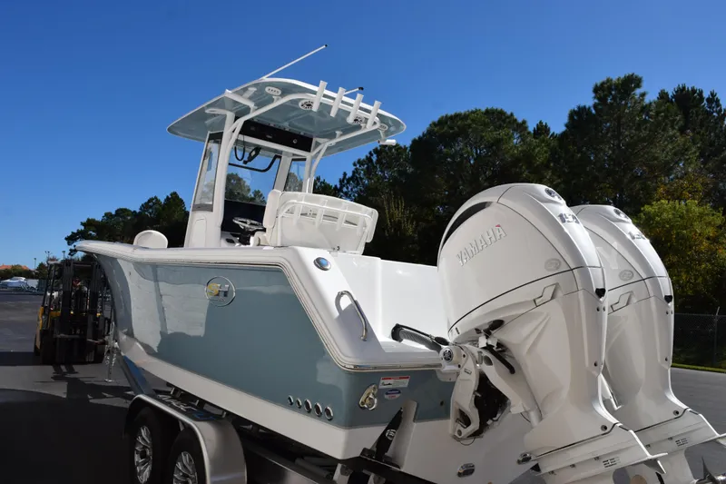 Slide: The Image of 2026 Sea Hunt Gamefish 25 boat with dual Yamaha engines on a trailer. - 6