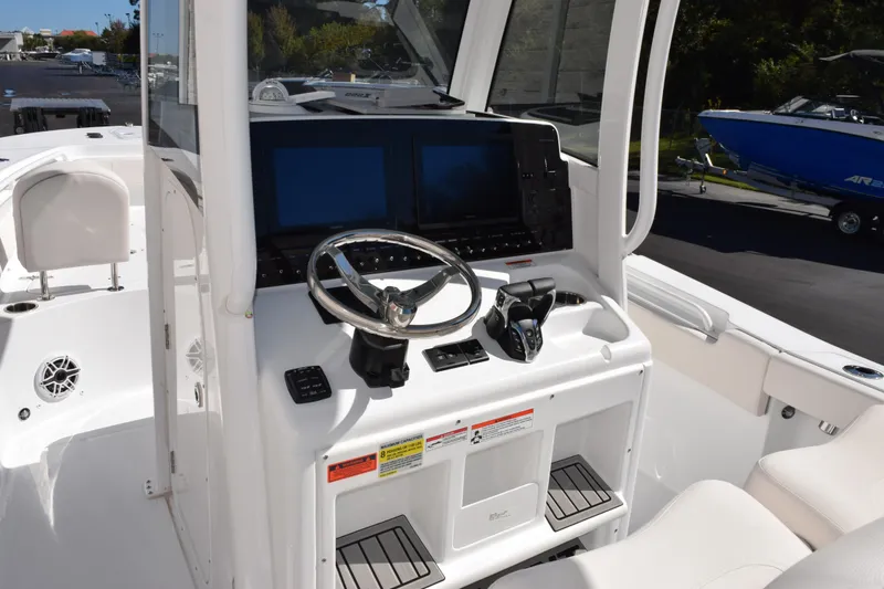 Slide: The Image of 2026 Sea Hunt Gamefish 25 boat cockpit with steering wheel and dual screens. - 9