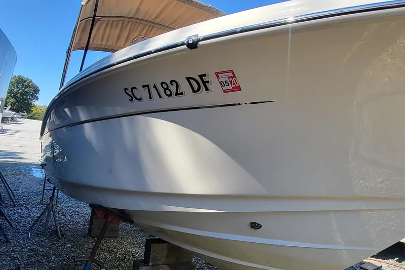 Slide: The Image of 2017 Scout 215 XSF boat with registration SC 7182 DF, parked outdoors. - 3