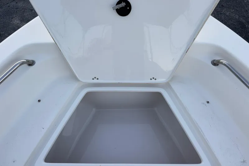 Slide: The Image of Open storage compartment on 2023 Key West 189 FS boat, featuring stainless steel handles. - 17