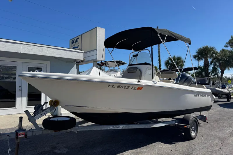 Slide: The Image of 2023 Key West 189 FS boat on trailer, parked outside dealership under clear blue sky. - 2
