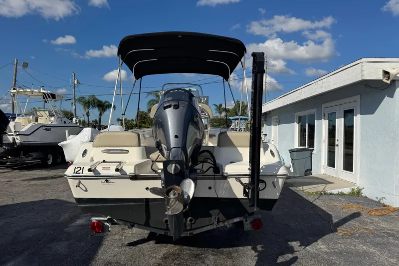 Slide: The Image of 2023 Key West 189 FS boat with outboard motor, parked outdoors under blue sky. - 3