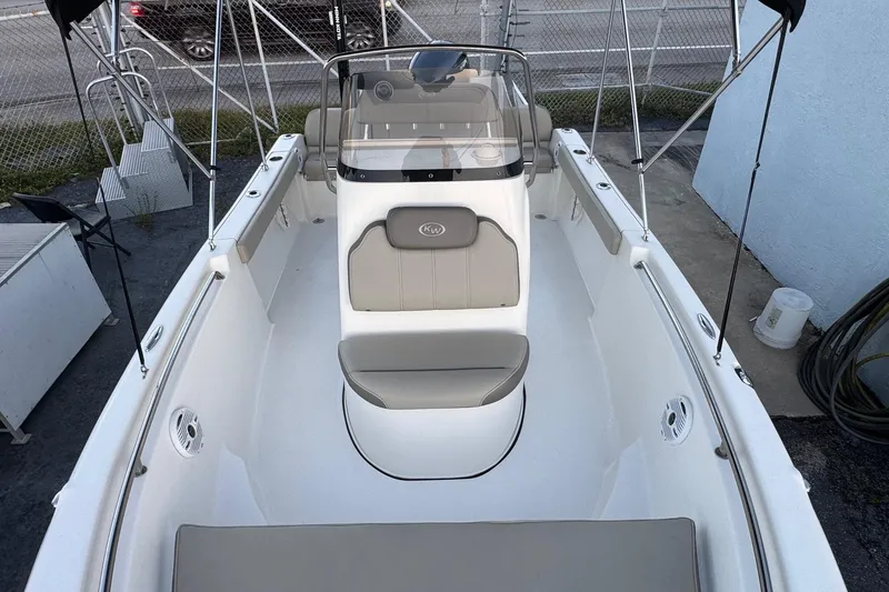 Slide: The Image of 2023 Key West 189 FS boat interior with seating and console, docked outdoors. - 6