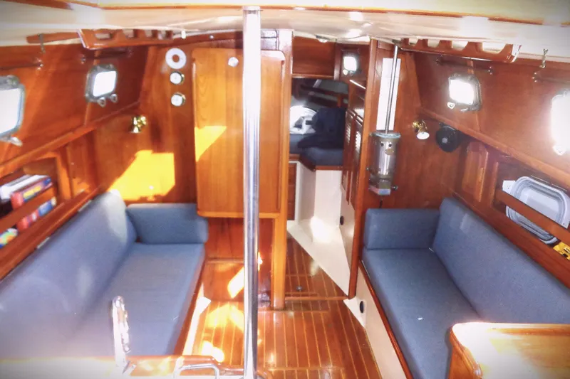 Slide: The Image of Interior of 1992 Pacific Seacraft 34 sailboat with wooden finish and blue seating. - 2