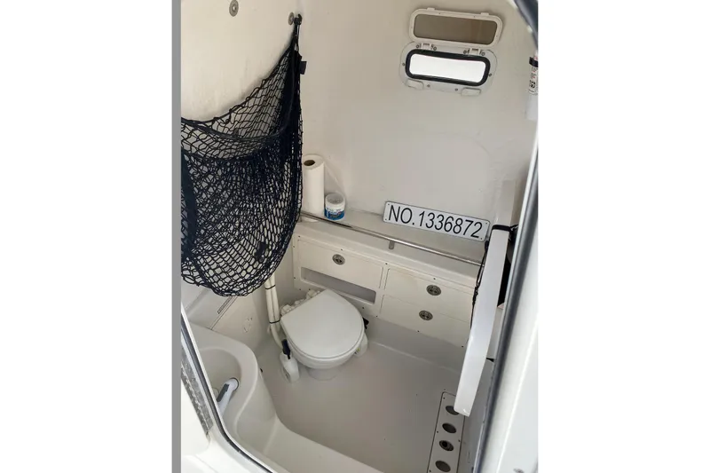 Slide: The Image of Interior of 2013 Sailfish 290 CC boat with toilet and storage compartments. - 10