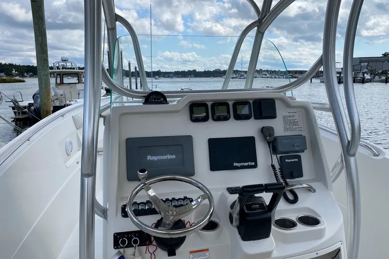 Slide: The Image of 2013 Sailfish 290 CC boat dashboard with Raymarine electronics, docked by the water. - 5