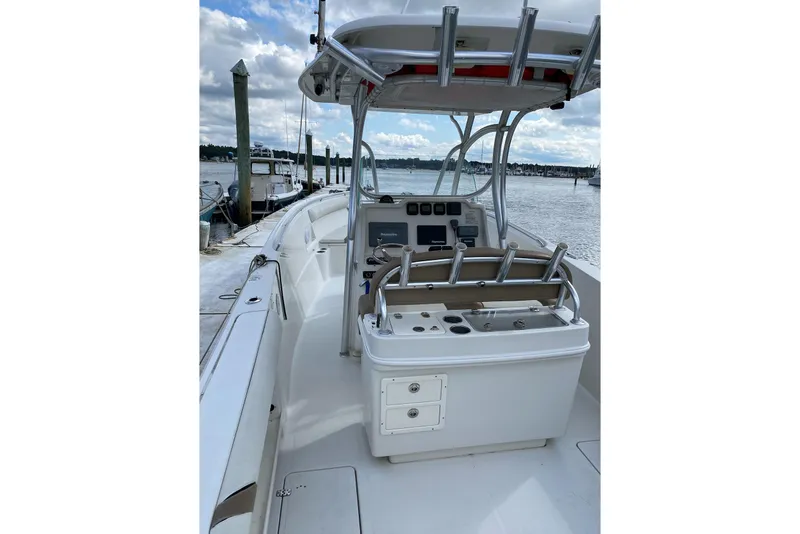 Slide: The Image of 2013 Sailfish 290 CC boat interior with helm, docked by the water. - 6