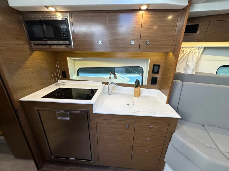 Slide: The Image of Galley with microwave and sink and 2 burner cook top and refrigerator - 5