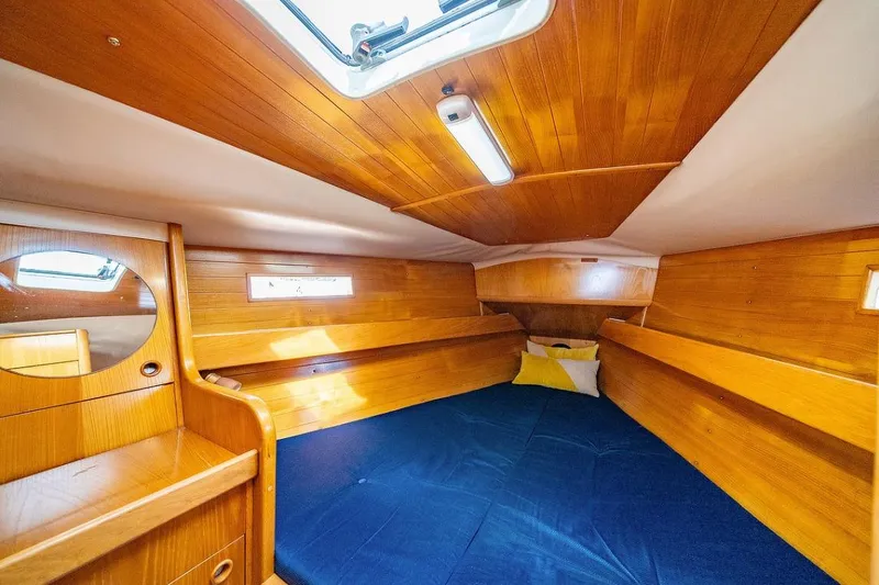 Slide: The Image of Interior of 1992 Beneteau Oceanis 350 sailboat with wooden finish and blue seating. - 8