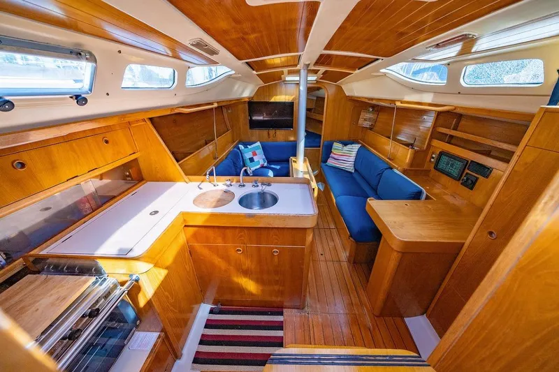 Slide: The Image of Cozy cabin interior of 1992 Beneteau Oceanis 350 sailboat with wooden finish and blue bedding. - 9
