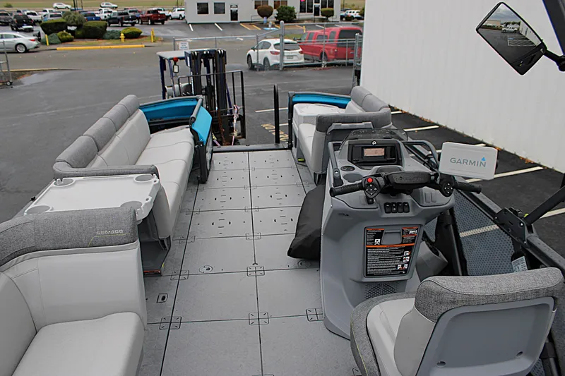 Slide: The Image of 2023 Sea-Doo Switch Cruise 21 interior with seating and control console, parked outdoors. - 18