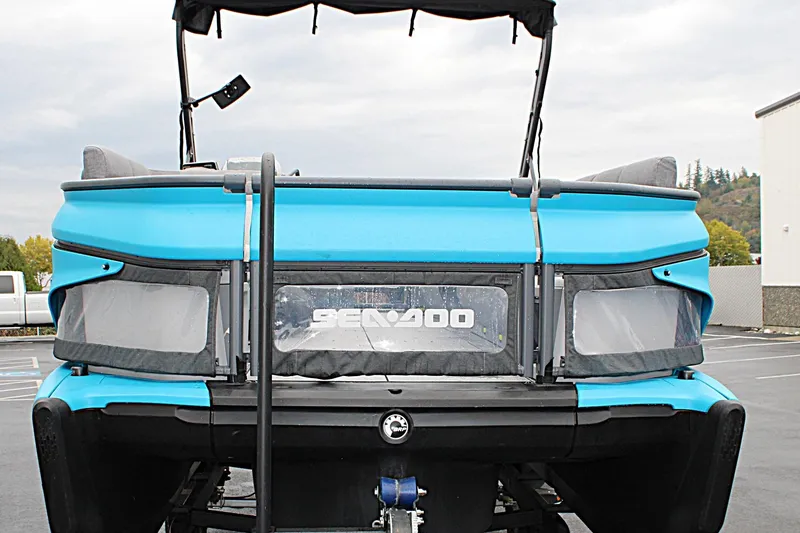 Slide: The Image of 2023 Sea-Doo Switch Cruise 21, blue exterior, parked in a lot, rear view. - 2