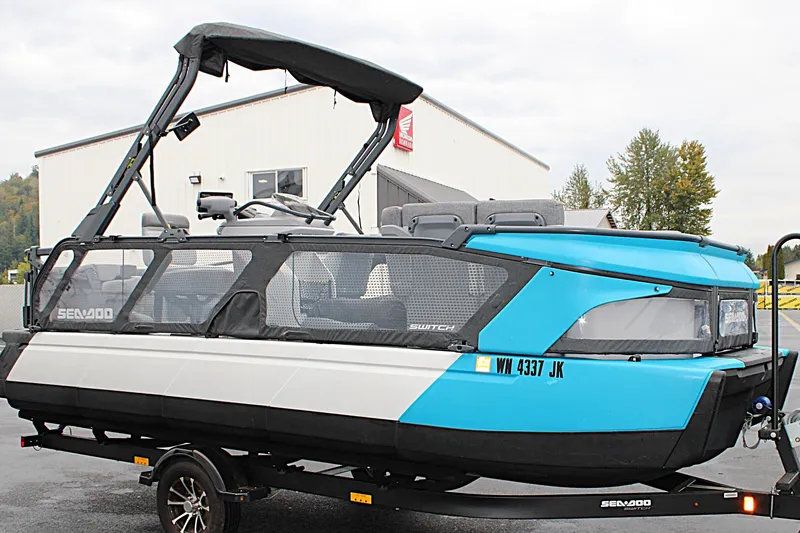 Slide: The Image of 2023 Sea-Doo Switch Cruise 21 pontoon boat on trailer, blue and white design. - 3