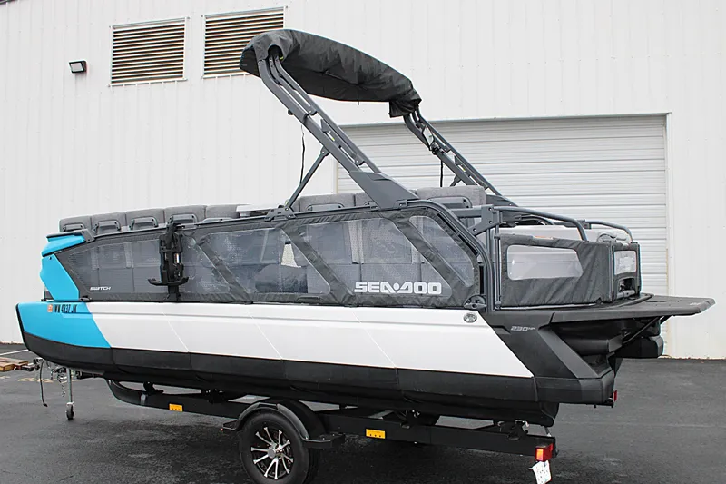 Slide: The Image of 2023 Sea-Doo Switch Cruise 21 pontoon boat parked outside a garage. - 7