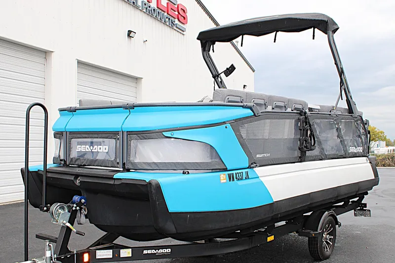 Slide: The Image of 2023 Sea-Doo Switch Cruise 21 pontoon boat on trailer, blue and white design. - 9