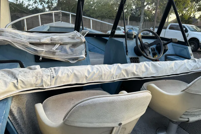 Slide: The Image of 1998 Klamath 18 Open boat interior with steering wheel and seats. - 11