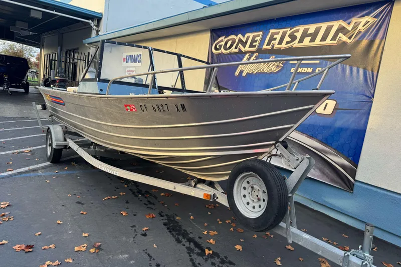 Slide: The Image of 1998 Klamath 18 Open boat on trailer, parked outside a fishing store. - 4