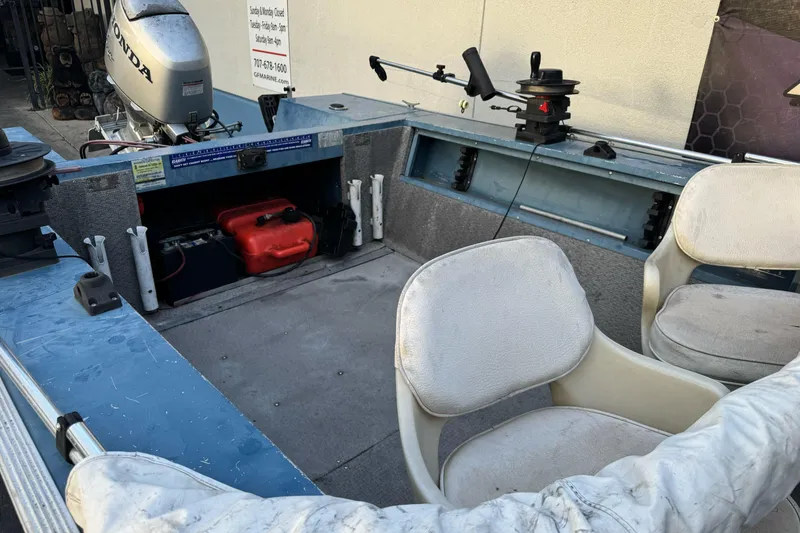 Slide: The Image of 1998 Klamath 18 Open boat interior with Honda motor and seating. - 8