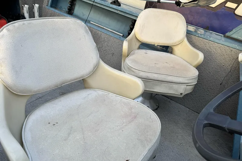 Slide: The Image of Two worn seats inside a 1998 Klamath 18 Open boat. - 9