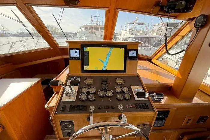 Slide: The Image of 1983 Egg Harbor 40 Sedan helm with navigation equipment and gauges in a marina setting. - 12