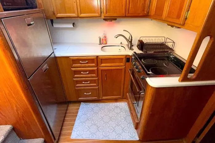 Slide: The Image of Compact kitchen in a 1983 Egg Harbor 40 Sedan boat with wooden cabinetry and modern appliances. - 13