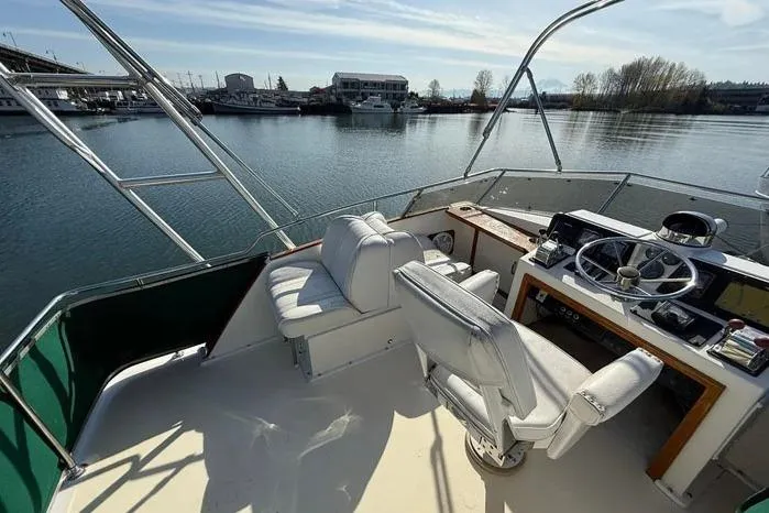 Slide: The Image of 1983 Egg Harbor 40 Sedan yacht helm with white seating, overlooking a serene marina. - 2