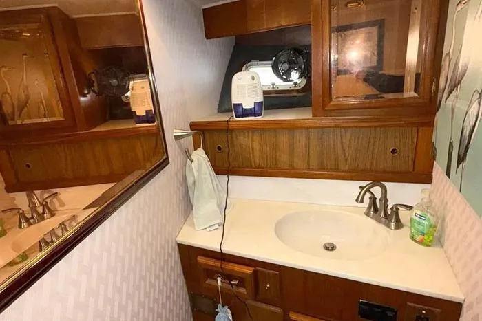 Slide: The Image of 1983 Egg Harbor 40 Sedan bathroom with wooden cabinets and sink. - 22
