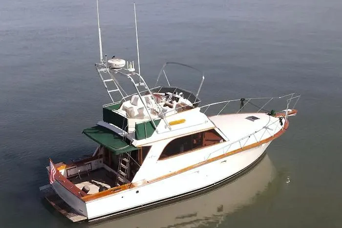 Slide: The Image of 1983 Egg Harbor 40 Sedan yacht on calm water, featuring classic design and spacious deck. - 7