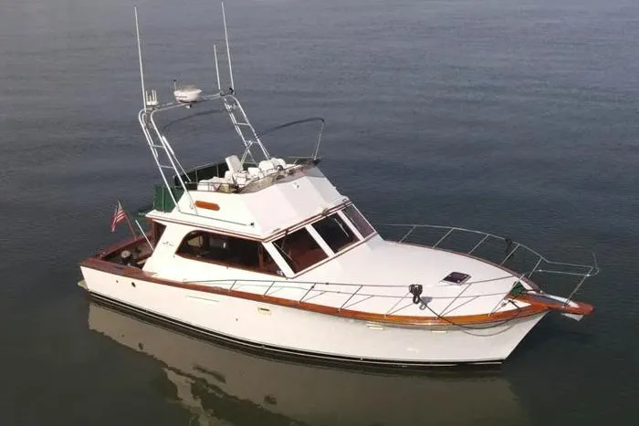 Slide: The Image of 1983 Egg Harbor 40 Sedan yacht on calm water, featuring classic design and American flag. - 8