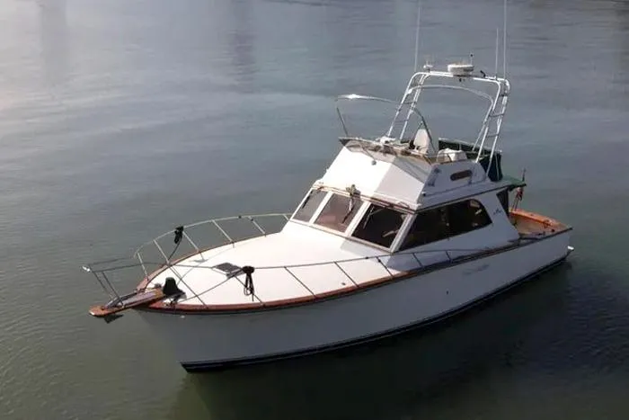 Slide: The Image of 1983 Egg Harbor 40 Sedan boat on calm water, showcasing classic design. - 9
