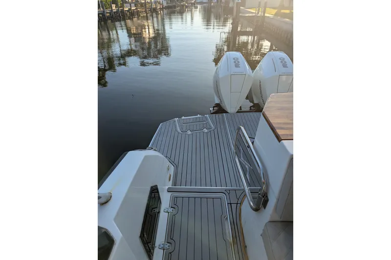 Slide: The Image of 2023 NX Boats 340 Sport Coupe docked with twin outboard engines. - 11