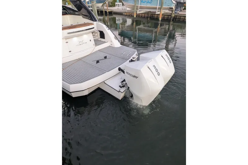 Slide: The Image of 2023 NX Boats 340 Sport Coupe with twin Mercury outboard engines in marina. - 13