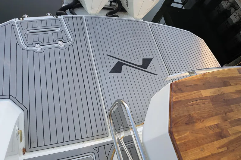 Slide: The Image of 2023 NX Boats 340 Sport Coupe deck with wood and gray detailing. - 16