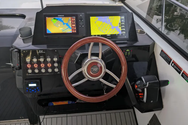 Slide: The Image of 2023 NX Boats 340 Sport Coupe dashboard with navigation screens and controls. - 22