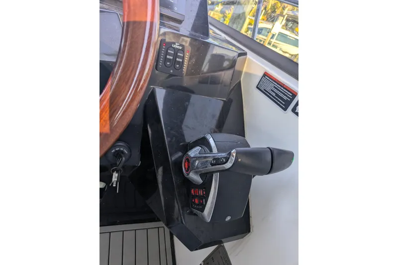 Slide: The Image of Control panel of 2023 NX Boats 340 Sport Coupe with steering wheel and throttle lever. - 24