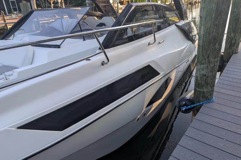 Slide: The Image of 2023 NX Boats 340 Sport Coupe docked, showcasing sleek design and modern features. - 27