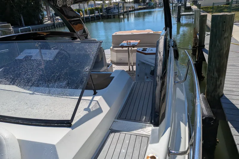 Slide: The Image of 2023 NX Boats 340 Sport Coupe docked, showcasing sleek design and modern features. - 38