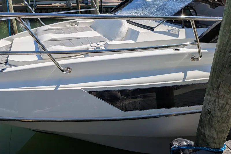 Slide: The Image of 2023 NX Boats 340 Sport Coupe, sleek design with sunbathing area, docked at marina. - 44
