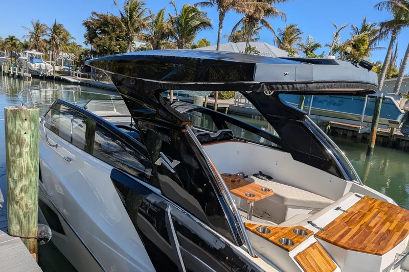 Slide: The Image of 2023 NX Boats 340 Sport Coupe docked, showcasing sleek design and luxurious interior. - 48
