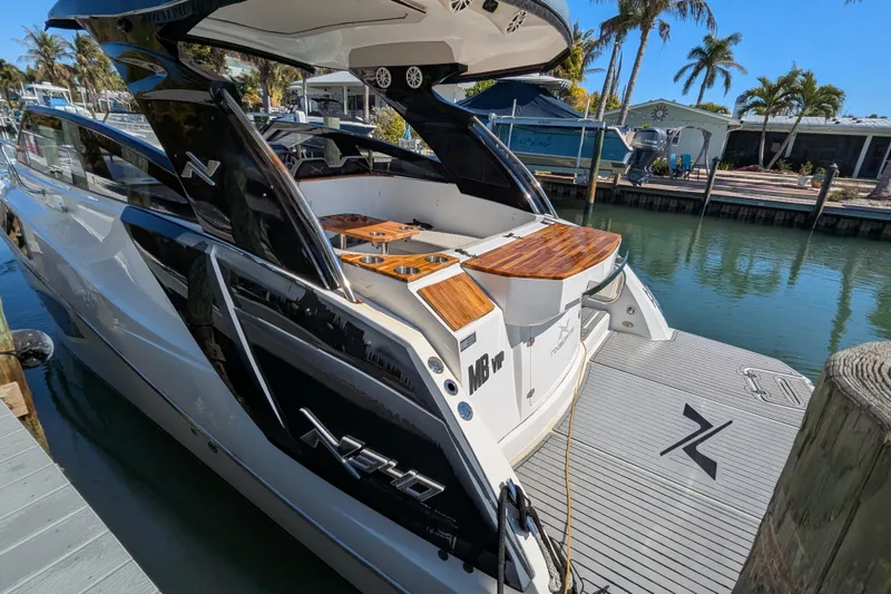 Slide: The Image of 2023 NX Boats 340 Sport Coupe docked, showcasing sleek design and luxurious features. - 52