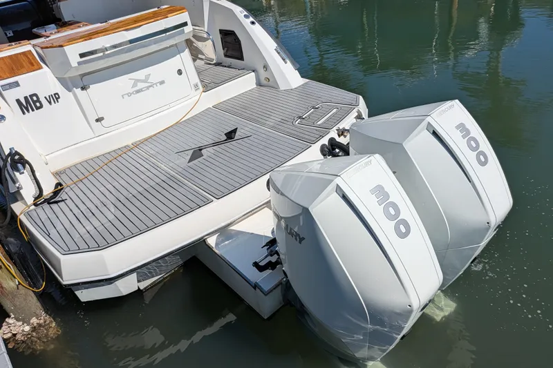 Slide: The Image of 2023 NX Boats 340 Sport Coupe with dual Mercury 300 engines docked on water. - 56