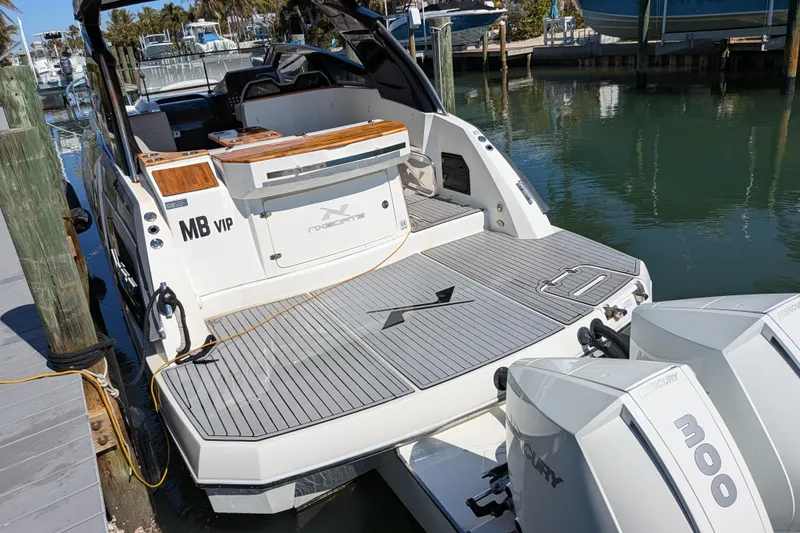 Slide: The Image of 2023 NX Boats 340 Sport Coupe docked with twin Mercury 300 engines. - 57