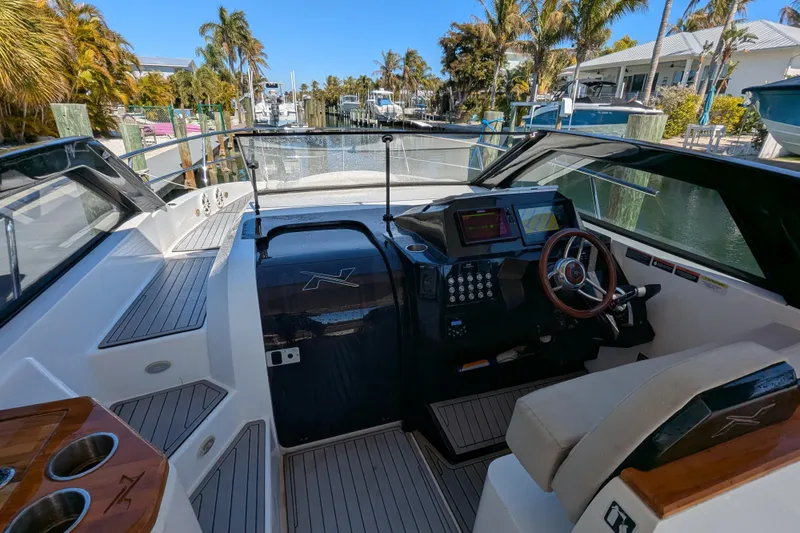 Slide: The Image of 2023 NX Boats 340 Sport Coupe cockpit with modern controls and luxurious seating. - 67