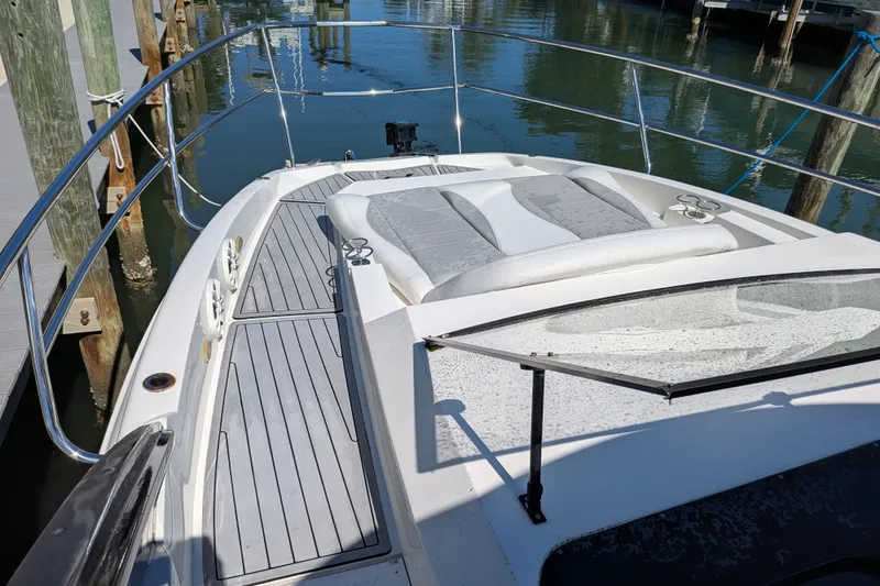 Slide: The Image of 2023 NX Boats 340 Sport Coupe, sleek deck view at marina. - 75