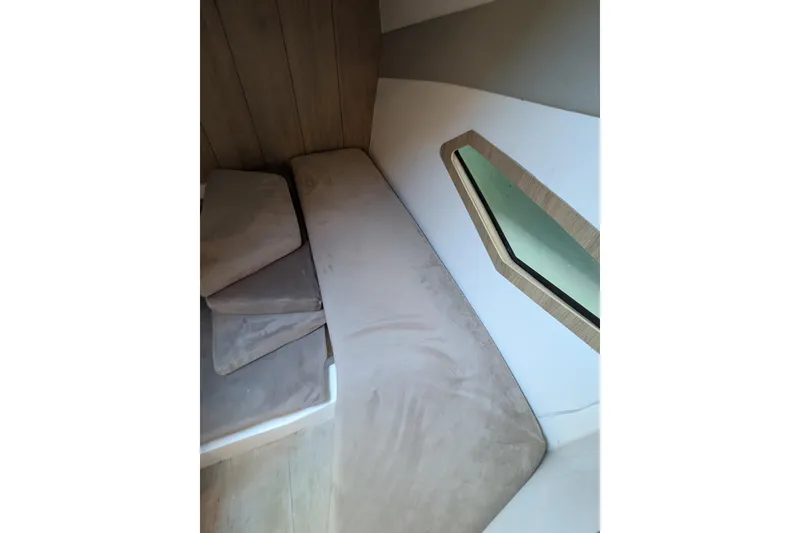 Slide: The Image of Interior cabin of 2023 NX Boats 340 Sport Coupe with cushioned seating and window. - 92