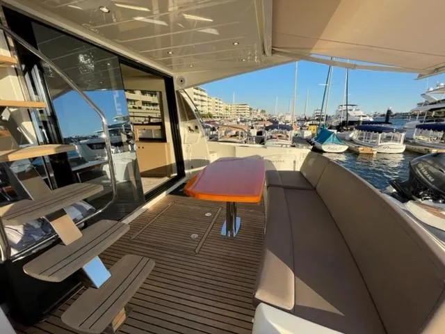 Slide: The Image of Luxurious 2017 Prestige 500 yacht deck with seating, table, and marina view. - 12