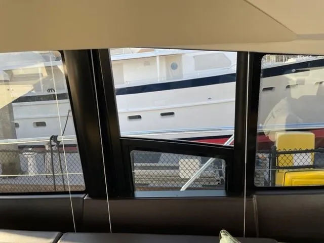 Slide: The Image of View from inside a 2017 Prestige 500 yacht, showing another boat docked outside. - 19