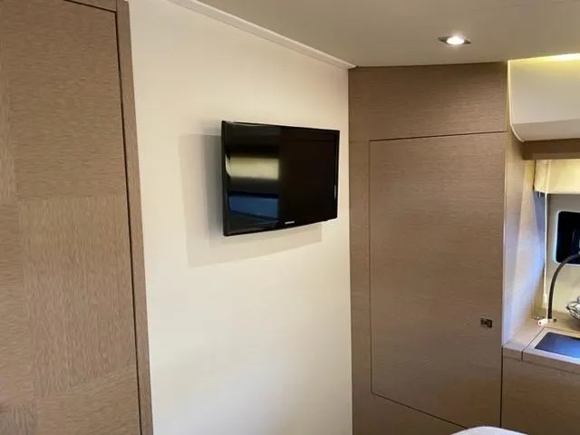 Slide: The Image of Wall-mounted TV in a 2017 Prestige 500 yacht interior with modern wood paneling. - 29